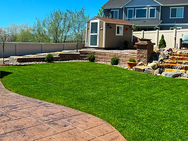 Artificial turf installation and landscaping in backyard by Easy Green Landscaping.