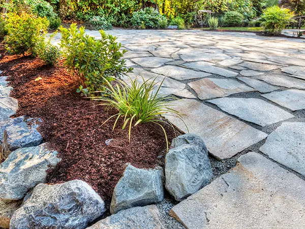 Natural flagstone walkway with landscaping elements by Easy Green Landscaping.