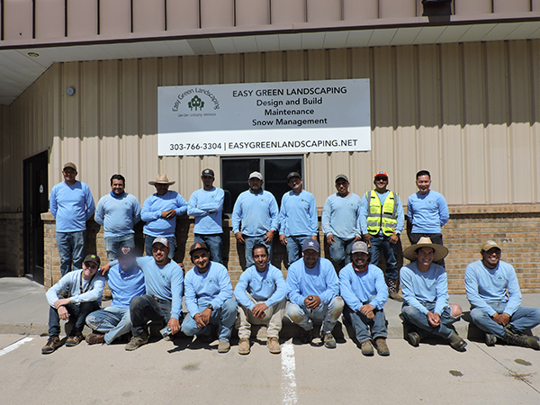 Easy Green Landscaping team posing outside office, showcasing professional landscaping and design crew.