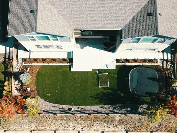 Beautifully landscaped backyard with artificial turf and pathways by Easy Green Landscaping.